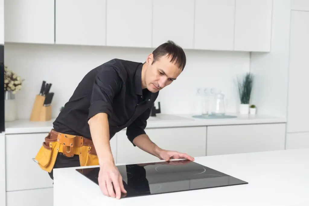 Man,Electrical,Repairs,Kitchen,Surface,Apartment.,Installing,Hob,In,Countertop.