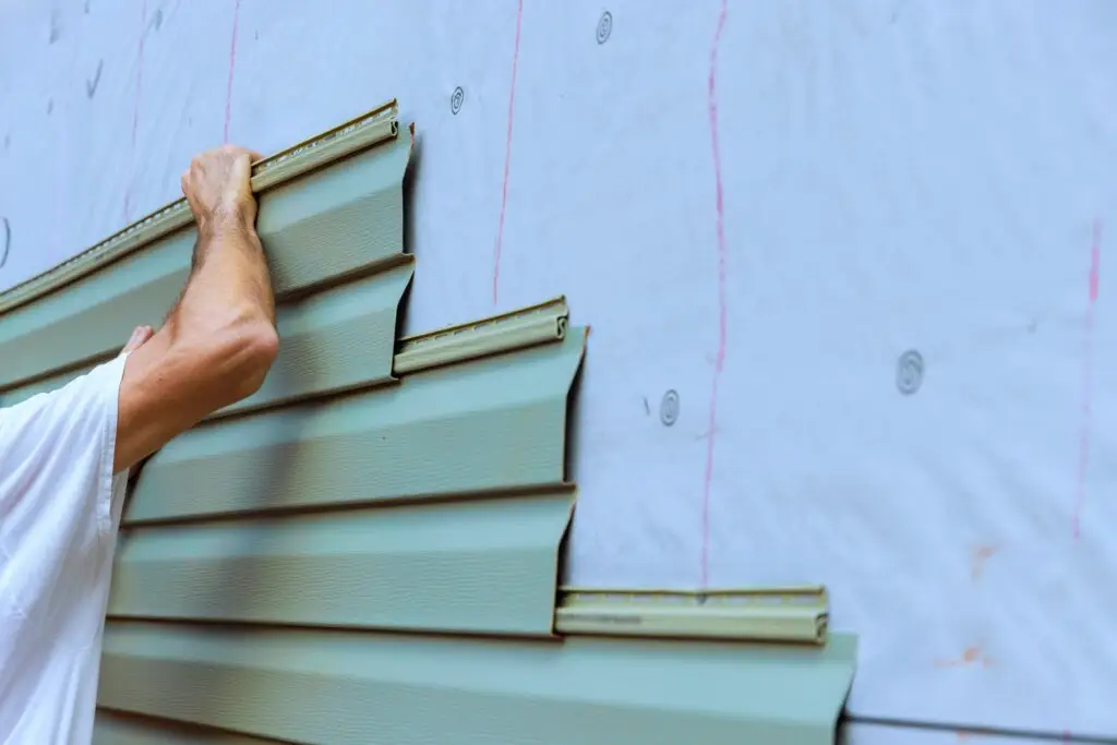 Construction,Worker,Carefully,Places,Installing,New,Pvc,Vinyl,Siding,Siding